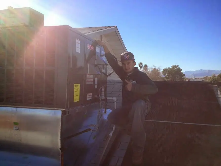 HVAC technician performing HVAC Inspection on a rooftop unit in Midlothian